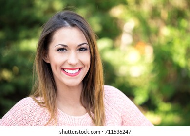 Beautiful Young Girl Smiling At The Camera In The Park Outside