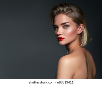 Beautiful young girl in studio on gray background. Close-up portrait. Hairstyle styling.Fashion, beauty, make-up, cosmetics, beauty salon, haircut, hairstyle, self-care, health.Smooth tanned skin.