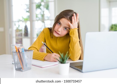 Beautiful young girl studying using computer laptop and writing on notebook stressed with hand on head, shocked with shame and surprise face, angry and frustrated. Fear and upset for mistake.