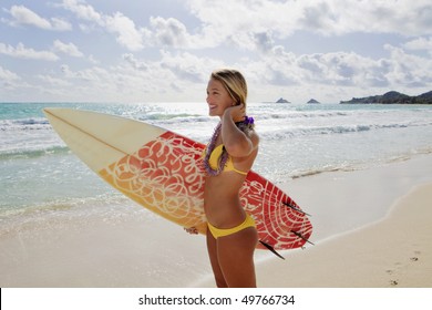 beautiful young girl with surfboard at kailua beach, hawaii