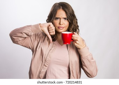 Beautiful young girl unhappy with a cup of warm drink.
