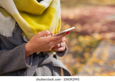 Beautiful Young Girl Using Smartphone In Park. Autumn Time. Close Up