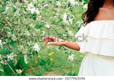 beautiful young girl in white dress in spring blossoming apple orchards