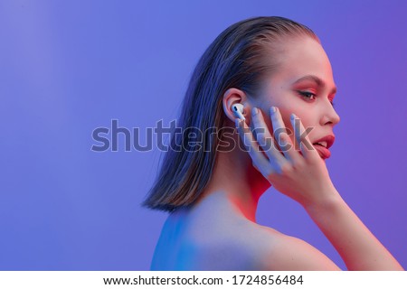 A beautiful young girl in wireless headphones listens to song with a good mood. bright colorful music poster.