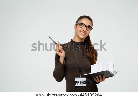 Beautiful young girl writing in notebook. Over white background