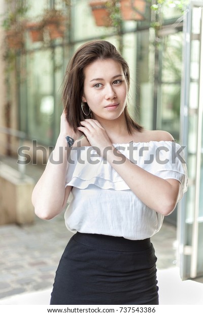Beautiful Young Half Asian Girl With Dark Hair In White Open Shoulders Top And Black Skirt