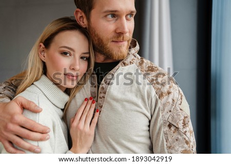 Beautiful young happy couple hugging and smiling indoors