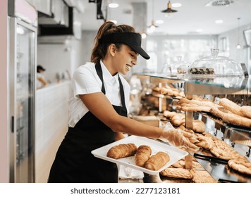 Beautiful young and happy female worker working in a modern bakery or fast food restaurant. - Powered by Shutterstock