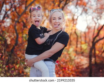 Beautiful Young Happy Mother With Little Girl. Closeup Of Happy Family On Walk In Foerest In Sunshine. Happy Family On Autumn Walk.