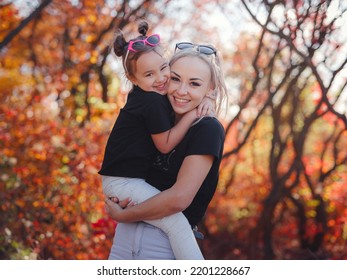 Beautiful Young Happy Mother With Little Girl. Closeup Of Happy Family On Walk In Foerest In Sunshine. Happy Family On Autumn Walk.