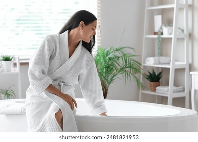 Beautiful young happy woman in bathrobe sitting at home - Powered by Shutterstock