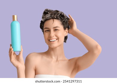 Beautiful young happy woman with bottle of shampoo on purple background - Powered by Shutterstock