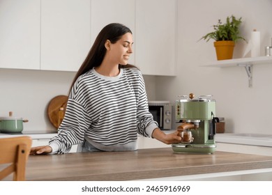 Beautiful young happy woman with modern coffee machine and cup of cappuccino in kitchen - Powered by Shutterstock