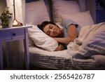 Beautiful young happy woman sleeping on bed in evening at home