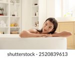 Beautiful young happy woman taking bath at home