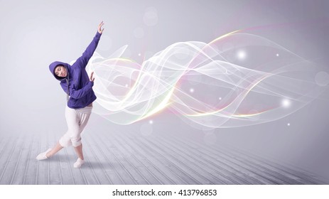 A Beautiful Young Hip Hop Dancer Dancing Contemporary Urban Street Dance In Front Of Grey Wall Background With Smokey Lines And Glitter Concept.