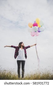 Beautiful young hipster woman holding with colorful of balloons outdoor, Freedom enjoy with nature. Women lifestyle concept.