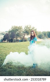 beautiful young hipster woman smoke fog in the park
