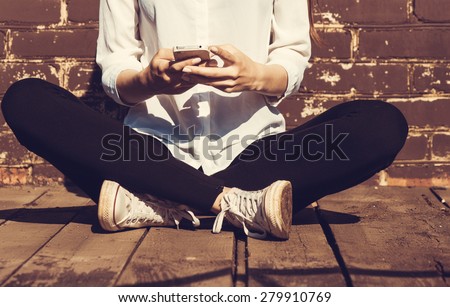 Beautiful young hipster woman using smart phone