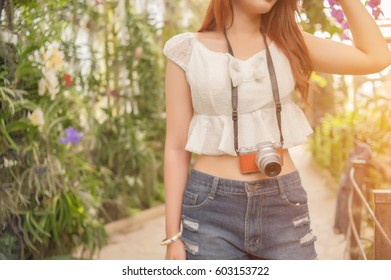 Beautiful young Hold camera in the flower garden 