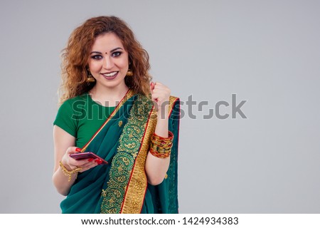 beautiful and young indian business woman in traditional india sari working using a smartphone phone.asian student girl remote work freelancer.