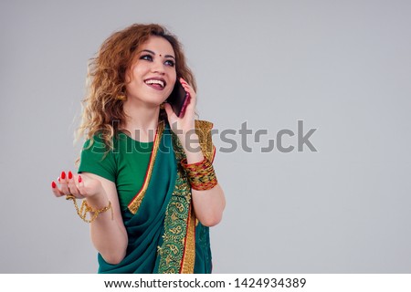 beautiful and young indian business woman in traditional india sari working using a smartphone phone.asian student girl remote work freelancer.