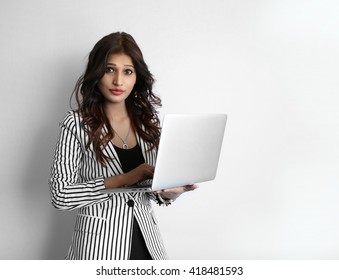 A Beautiful Young Indian Woman Working On Laptop Against A White Background