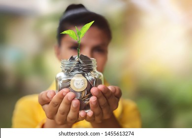 Beautiful Young Indian Women Holding Money Coins In Glass Jar With Plant In His Hand For Financial And Saving