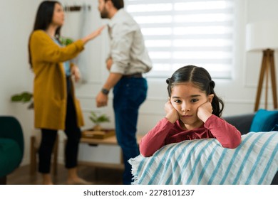 Beautiful young kid making eye contact looking sad while her parents are arguing at home before a divorce - Shutterstock ID 2278101237