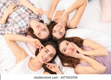 Beautiful young ladies on bed at pamper party, above view. Woman's Day