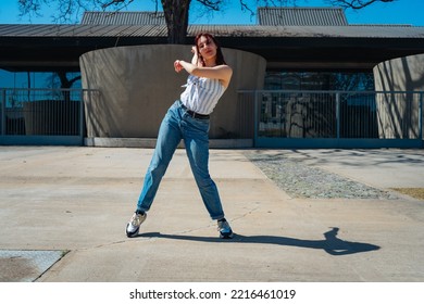 Beautiful Young Latina Dancing Happily In The Street While Partying With Jumps And Somersaults. Concept Of Joy, Street Dance, Hip Hop.