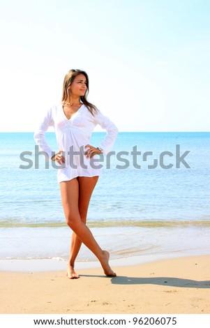 beautiful young latino woman wearing a white shirt portrait on beach