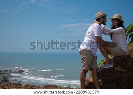 Beautiful young lovely attractive tourist couple looking each other embracing love, smiling cuddling enjoying Lakshadweep islands, view of Chapora fort in Goa, India. Baga, Candolim, Vagator Valentine