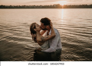 Beautiful young loving couple man and woman hug, kiss in lake at sunrise. Holidays at sea on the beach, sunset, morning, honeymoon, tropics, ocean, girlfriend, relationship. Emotional, fun - Powered by Shutterstock