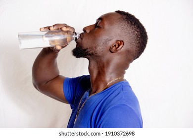 BEAUTIFUL YOUNG MAN WITH BEAUTIFUL BEARD TAKES PLEASURE OF DRINKING WATER, DRESSING IN BLUE.