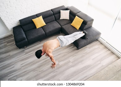 Beautiful Young Man Training And Working Out. Handsome Hispanic Male Athlete Exercising With A Chest Routine For Wellness In His Living Room. Latino People Doing Pushups And Sport At Home.