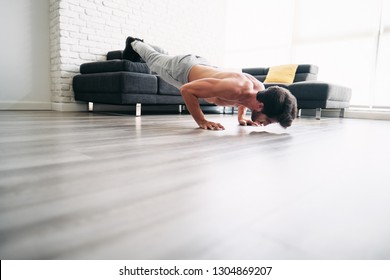 Beautiful Young Man Training And Working Out. Handsome Hispanic Male Athlete Exercising With A Chest Routine For Wellness In His Living Room. Latino People Doing Pushups And Sport At Home.