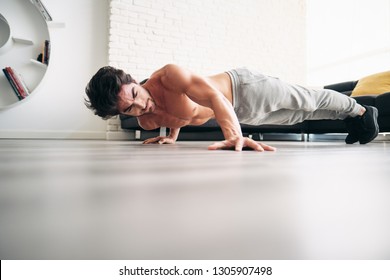 Beautiful Young Man Training And Working Out. Handsome Hispanic Male Athlete Exercising With A Chest Routine For Wellness In His Living Room. Latino People Doing Archer Pushups And Sport At Home.