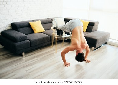 Beautiful Young Man Training And Working Out. Handsome Hispanic Male Athlete Exercising With A Chest Routine For Wellness In His Living Room. Latino People Doing Inclined Pushups And Sport At Home.