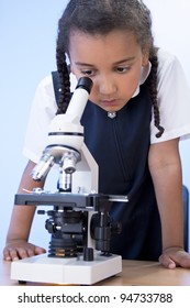 A Beautiful Young Mixed Race African American Girl Child Using A Microscope In A School Laboratory