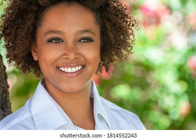 Beautiful young mixed race black African American woman with perfect teeth smiling and relaxing outside in summer sunshine - Shutterstock ID 1814552243
