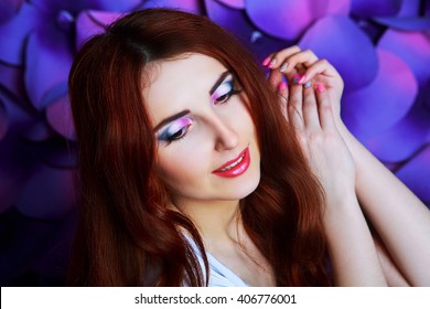 beautiful young model with long red hair and creative colorful makeup, studio photo