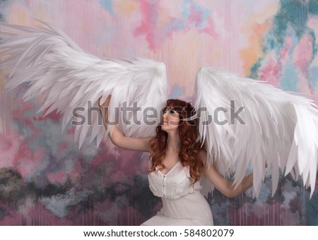 beautiful young model with open angel wings  with pink sky background