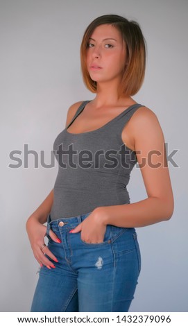 beautiful young model pose in studio light whit grey shirt and jenas