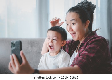 Beautiful Young Mom And Cute Little Boy Are Sitting Together, Using A Smart Phone And Smiling.asian People.vdo Call Or Take A Selfie Life Style Concept.