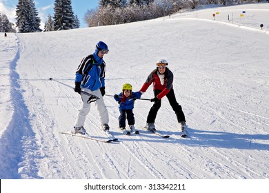 Beautiful Young Mom, Dad And Their Toddler Boy, Skiing In The Mountains, Winter Time