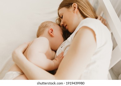 Beautiful Young Mom And Her Cute Little Baby Sleeping In Bed At Home