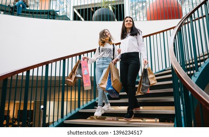 Beautiful Young Mom And Teenage Daughter Are Holding Shopping Bags, Shopping In Mall. Family Shopping.