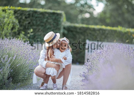 Beautiful young mother and her little daughter in blooming lavender. International family. Blooming lavender.