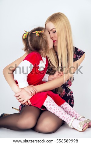 Beautiful young mother kissing daughter
